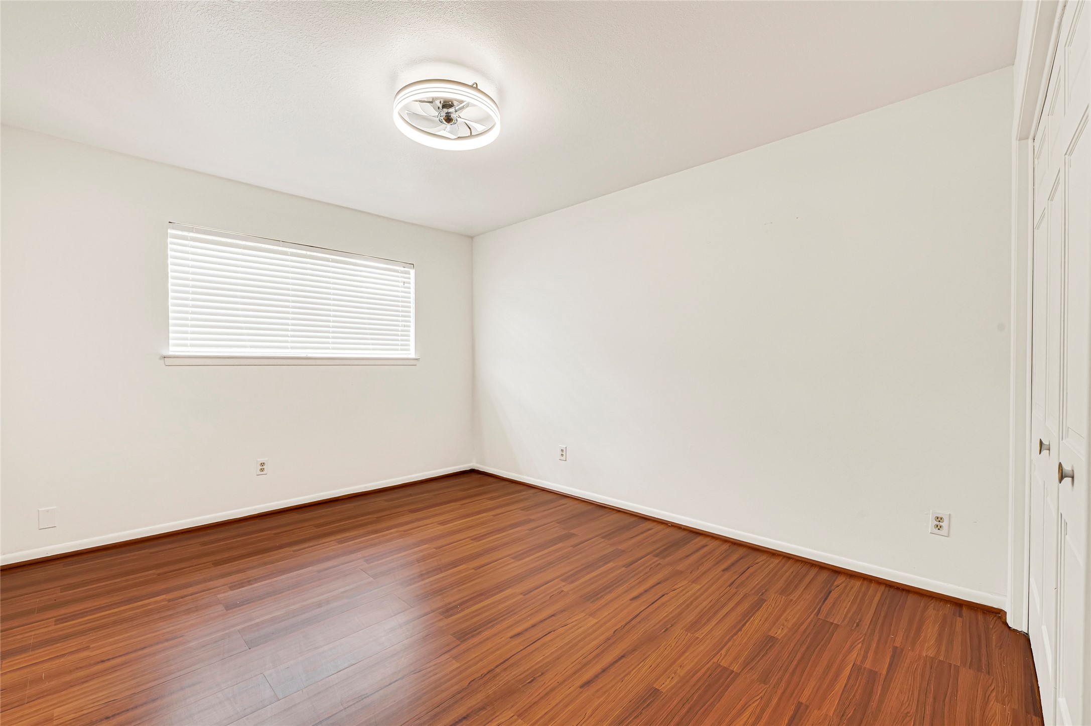 7302 Redding Road Houston, TX 77036 - Photo 7 of 26 an empty room with wooden floor and windows