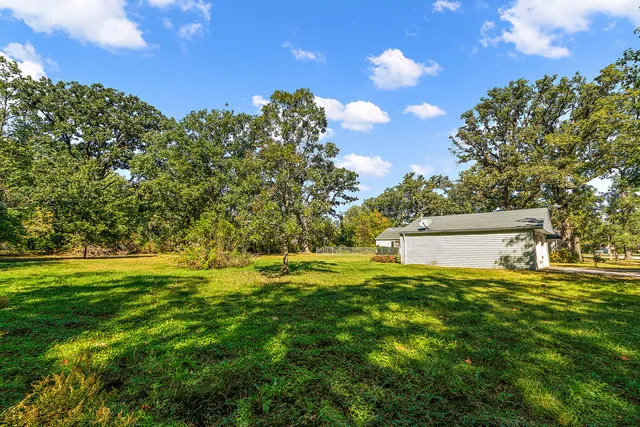 a backyard of a house with lots of green space and outdoor seating