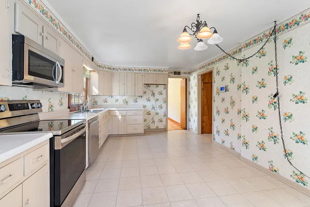 a kitchen with stainless steel appliances a stove sink microwave and cabinets