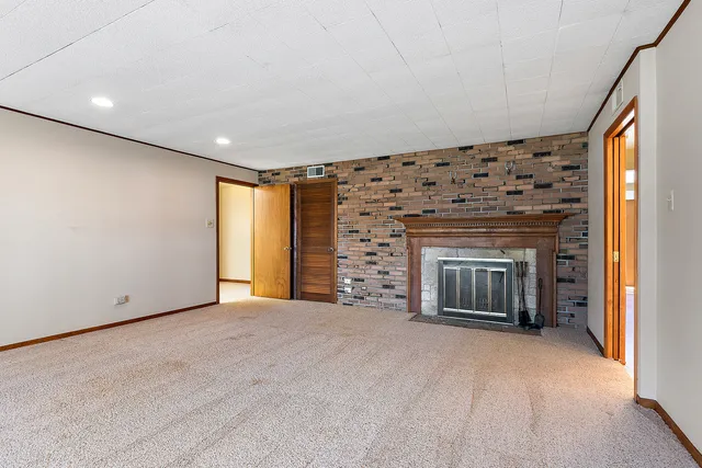 a view of an empty room with a fireplace and a window