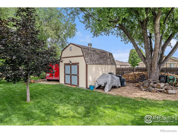 a view of a chair and table in backyard of the house