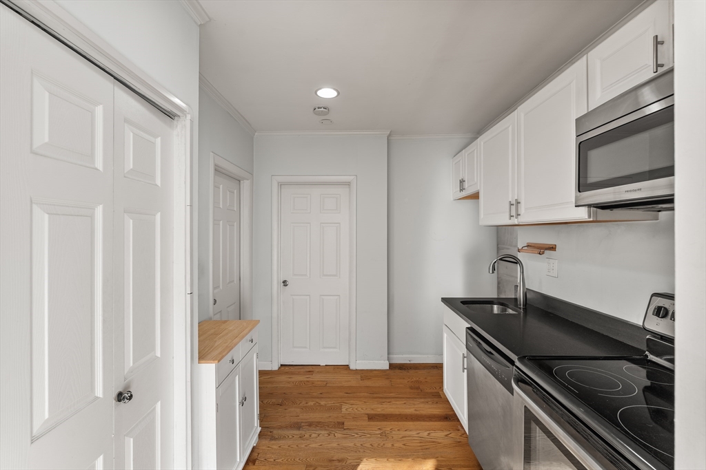 7 Burrill Place, Unit 1 Boston, MA 02127 - Photo 3 of 7 a kitchen with stainless steel appliances a stove and a refrigerator