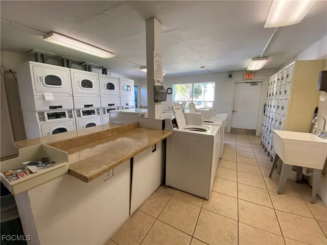 a large white room with a washing machine and sink