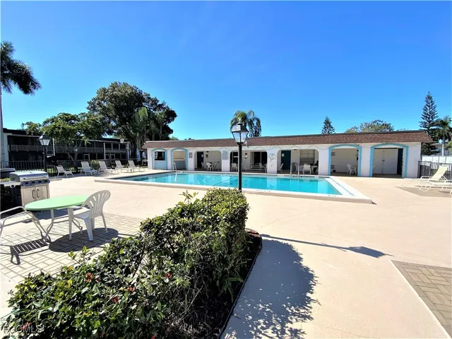 a view of a house with swimming pool and sitting area