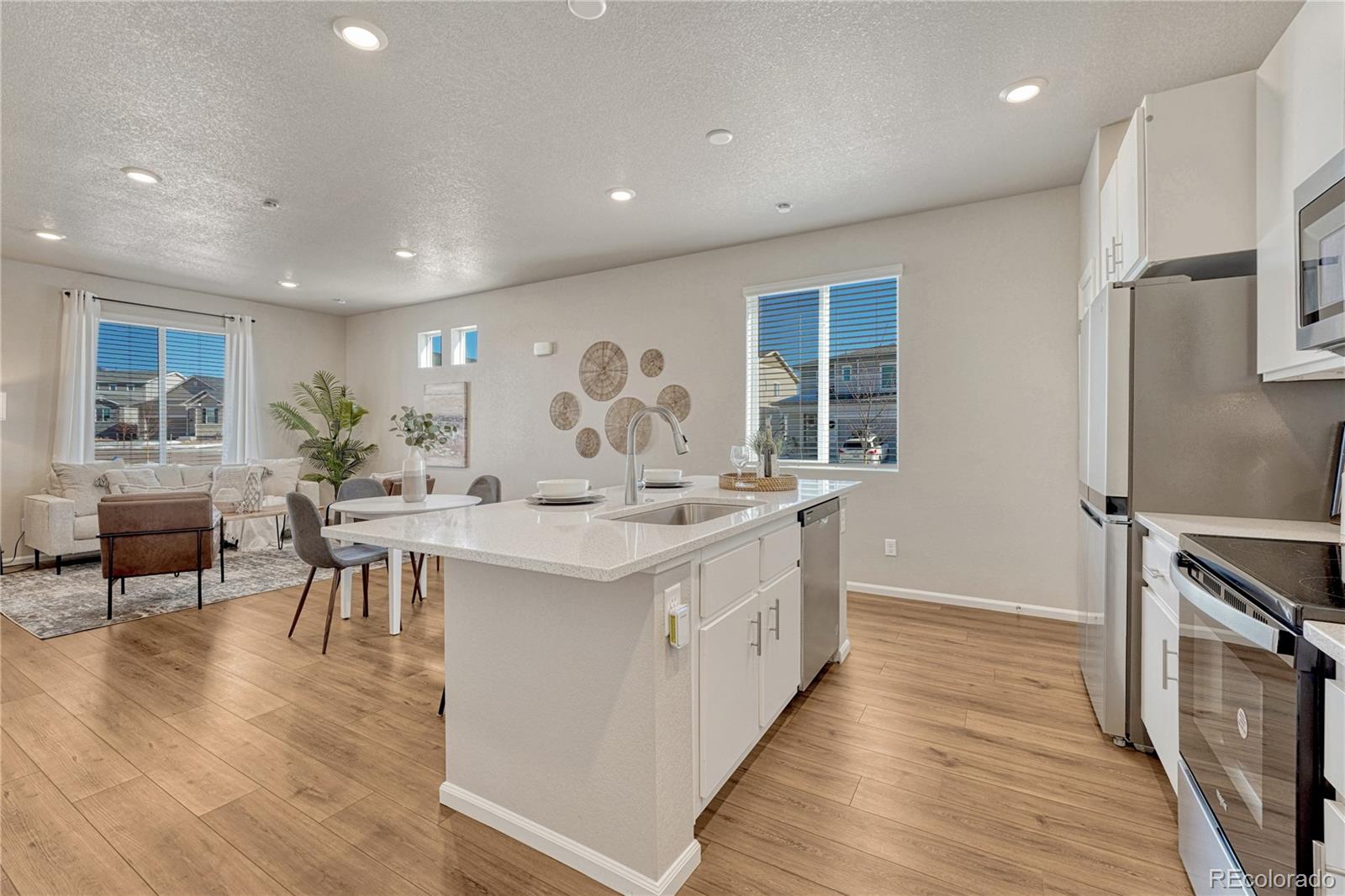 5861 Dakan Loop Colorado Springs, CO 80927 - Photo 13 of 29 a large kitchen with stainless steel appliances a large counter top a sink and a refrigerator