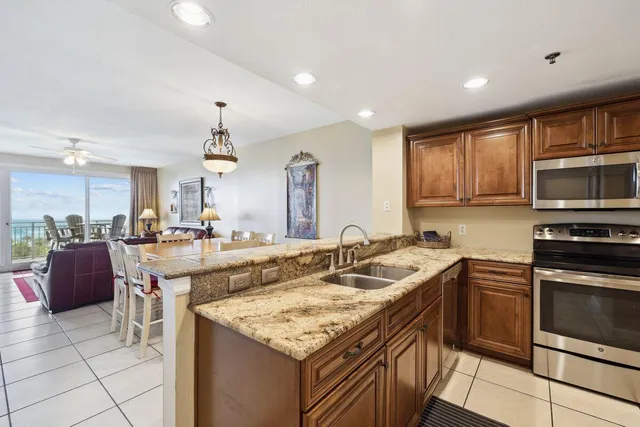 a kitchen with granite countertop a sink a counter top space appliances and cabinets