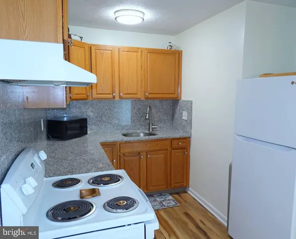 a view of a kitchen area with furniture and wooden floor