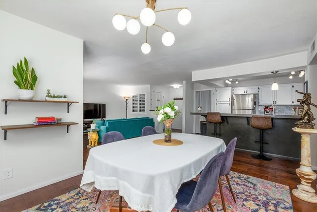 a kitchen with stainless steel appliances kitchen island granite countertop a table chairs refrigerator and a sink