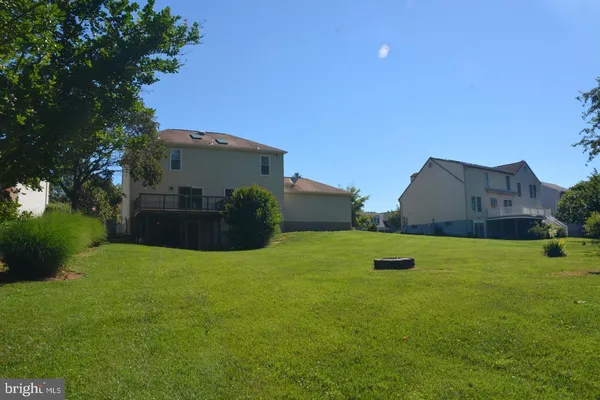 a view of a big house with a big yard and a large tree