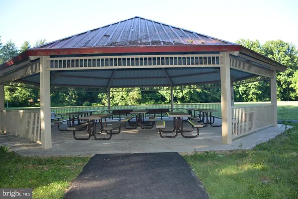 a view of a patio with table and chairs under an umbrella with a small yard