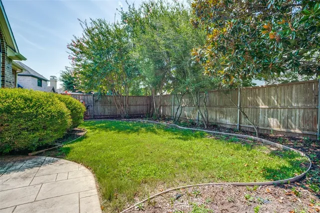 a view of a backyard with a small pool and wooden fence