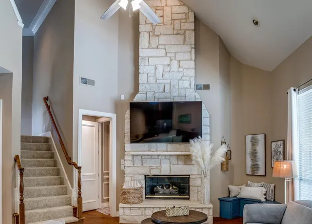 a living room with furniture a flat screen tv and a fireplace