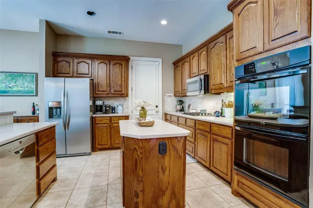 a kitchen with stainless steel appliances granite countertop a refrigerator a sink and a stove