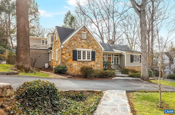 a front view of a house with a yard and trees