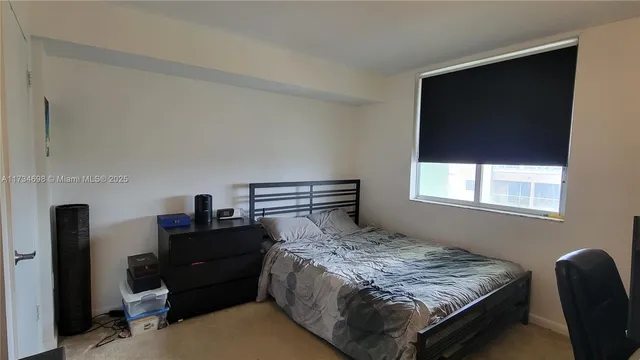 a bedroom with a bed and a flat tv screen on dresser