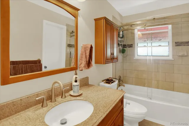 a bathroom with a granite countertop sink and a mirror