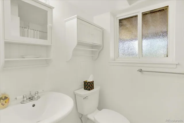 a white toilet sitting next to a bathroom sink