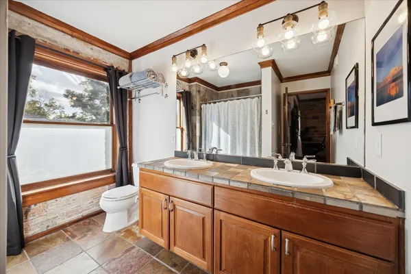 a bathroom with a granite countertop sink mirror vanity and toilet