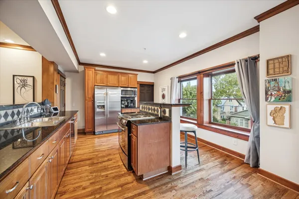 a kitchen with stainless steel appliances granite countertop sink stove and wooden floor