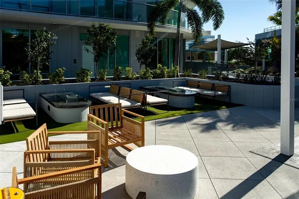 a view of a patio with table and chairs potted plants and palm tree
