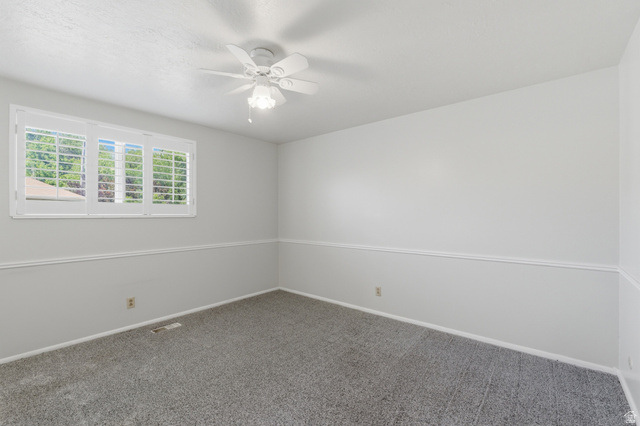148 Tennyson Avenue Sandy, UT 84070 - Photo 19 of 55 Neutral interior room featuring white window shutters, a ceiling fan with integrated lighting, and gray carpeting