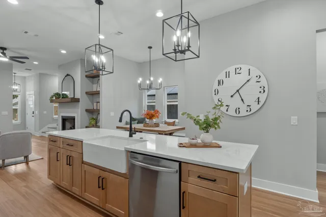 a kitchen with a sink a clock and cabinets