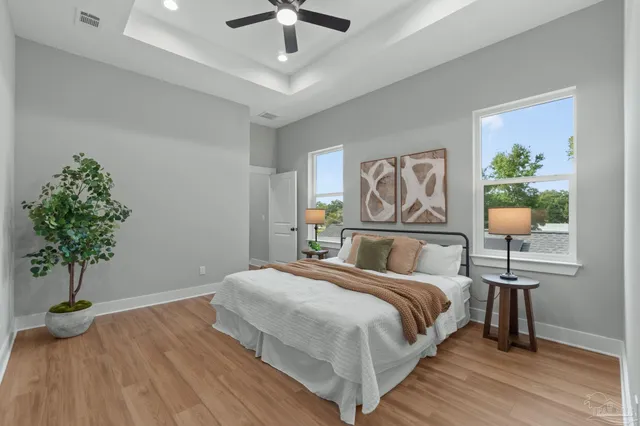 a bedroom with a bed potted plant and a chandelier