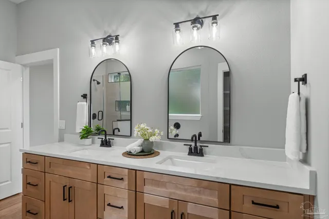 a bathroom with double vanity sinks and a mirror
