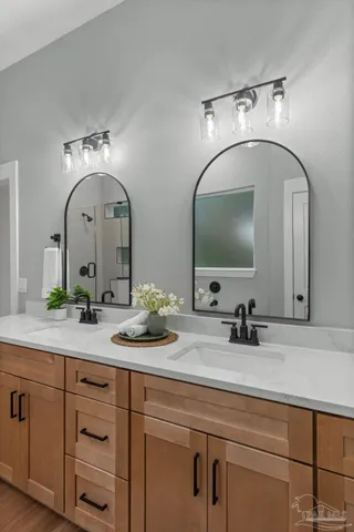 a bathroom with double vanity sinks and a mirror