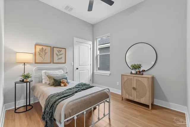 a bedroom with a bed and a potted plant on dresser