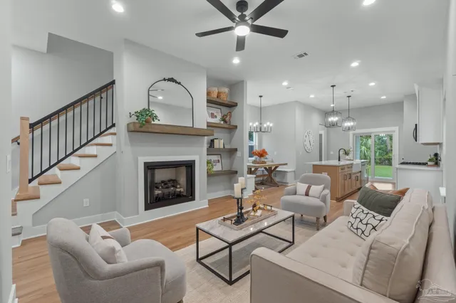 a living room with furniture a fireplace and a ceiling fan