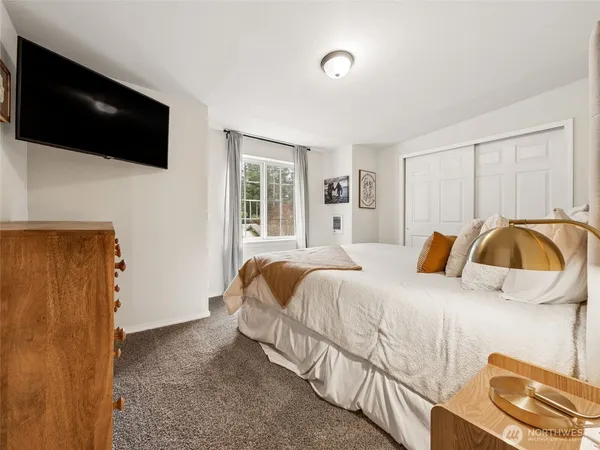 a bedroom with a bed and a flat screen tv