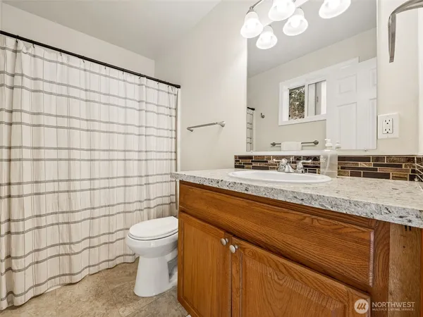 a bathroom with a granite countertop sink a toilet and shower