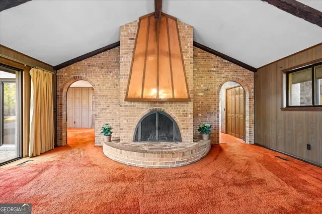 a view of an empty room with a fireplace and a window