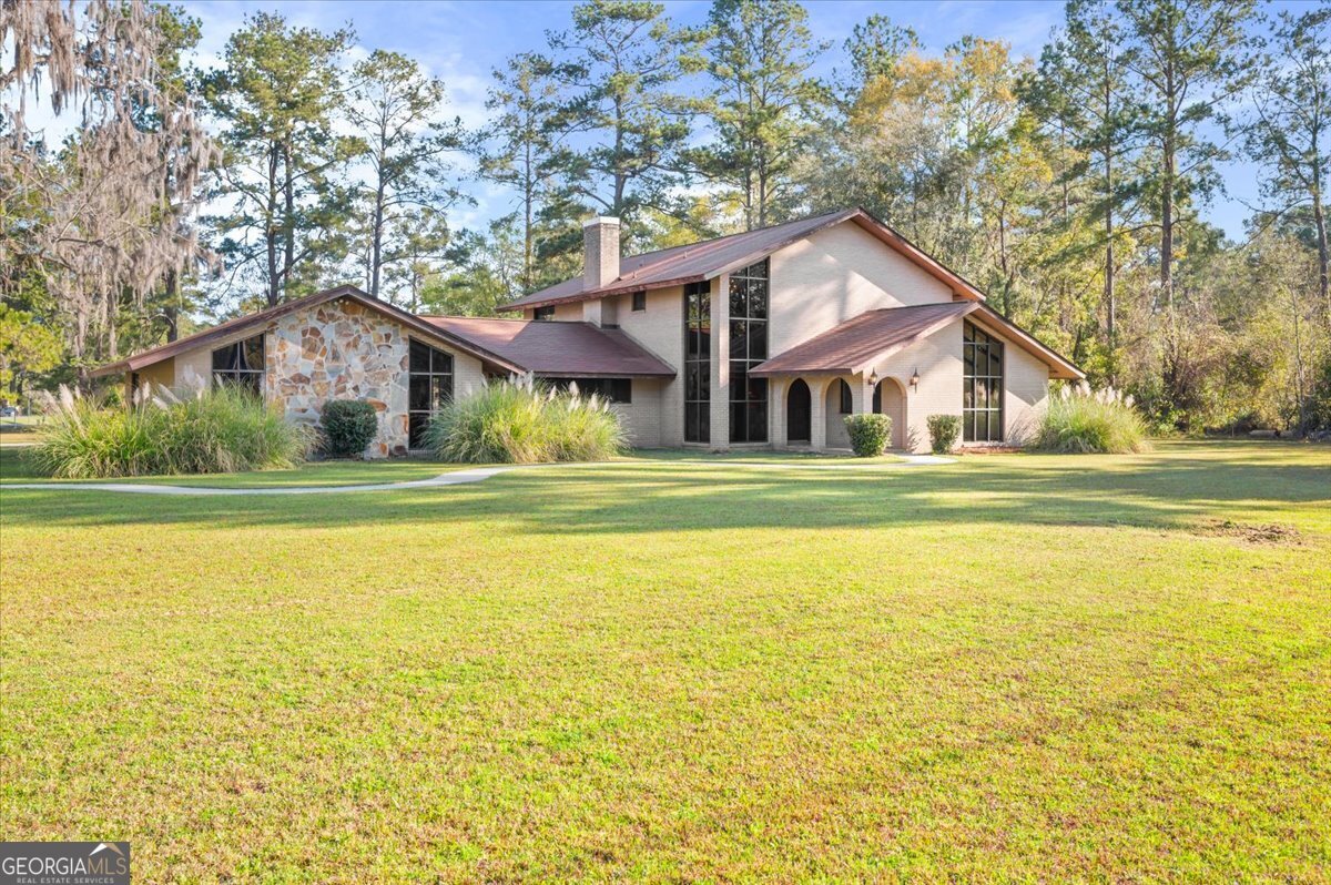 2066 Cherokee Street Waycross, GA 31503 - Photo 3 of 56 a front view of a house with a garden