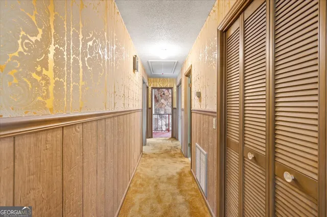 a view of a house with a big yard and large trees