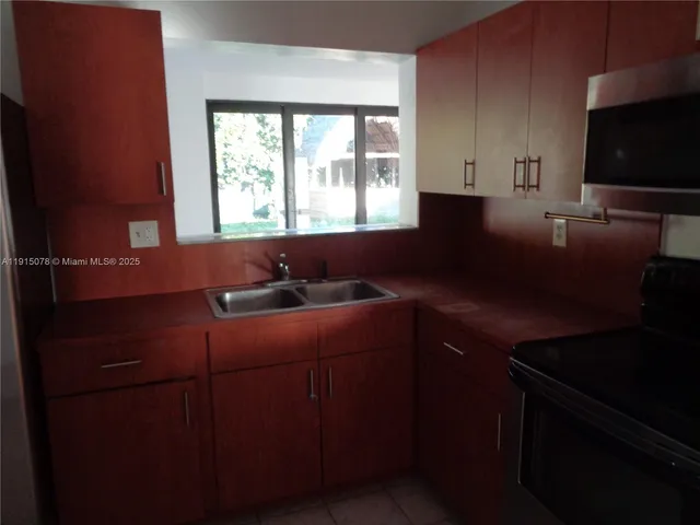 a kitchen with granite countertop white cabinets and stainless steel appliances
