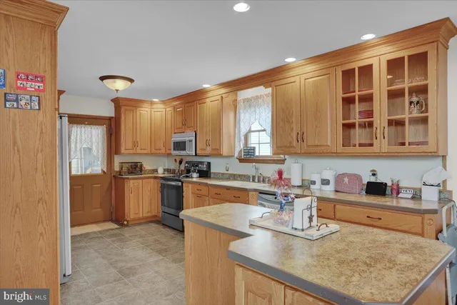a living room with wooden floor stairs and a chandelier