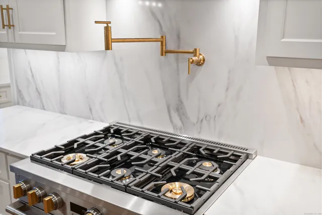 a kitchen with stainless steel appliances a stove a refrigerator and a cabinets