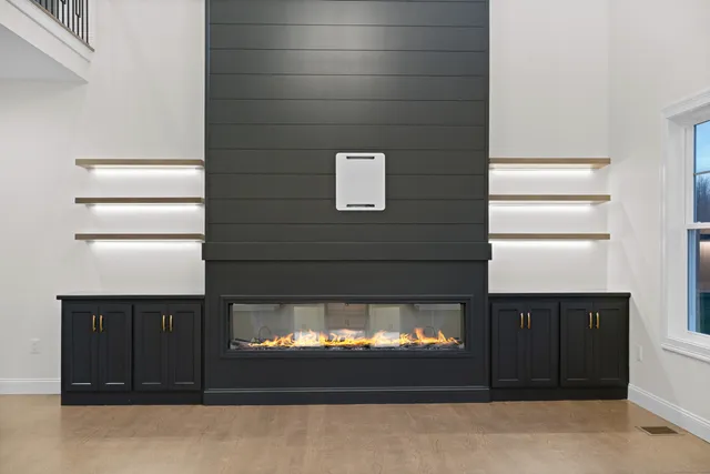 an empty room with a chandelier fan and windows