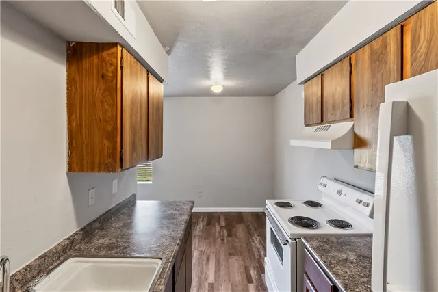 a view of a kitchen with wooden floor and electronic appliances