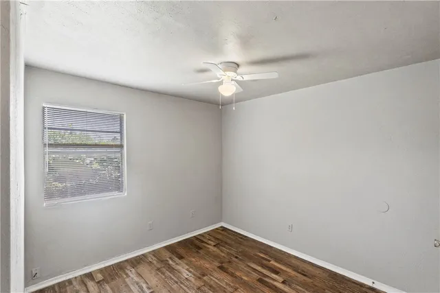 an empty room with a window and a fan