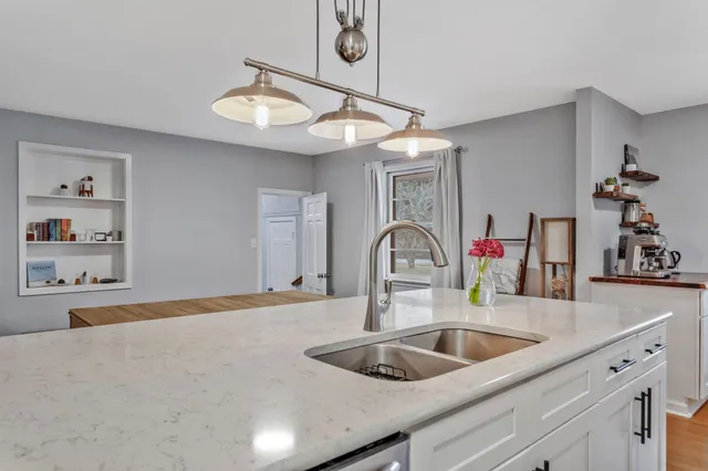 a kitchen with a sink a counter space and a chandelier