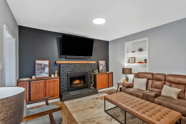 a living room with furniture a flat screen tv and a fireplace