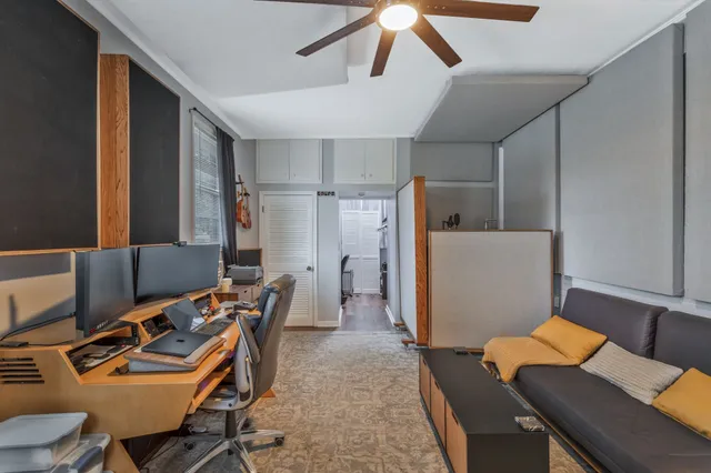 a room with furniture a rug and a ceiling fan