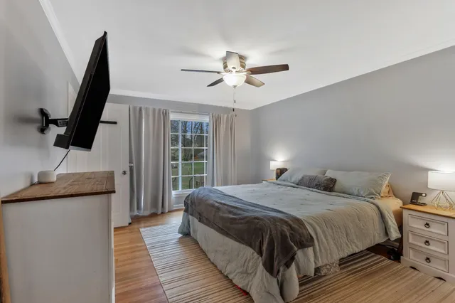 a bedroom with a bed and a flat tv screen on the dresser