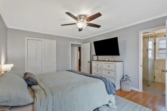 a bed room with a bed a television and a large window