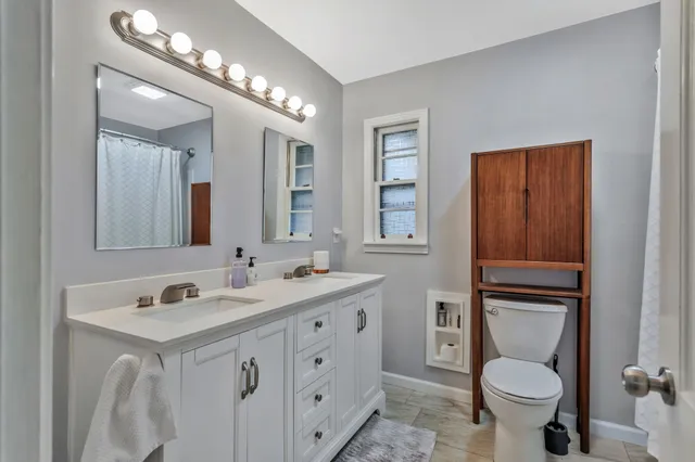 a bathroom with a toilet sink and mirror