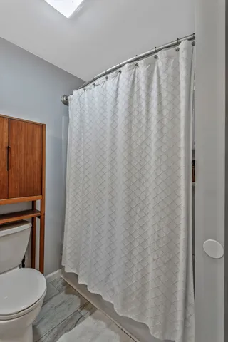 a white toilet sitting next to a shower curtain