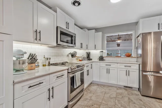 a kitchen with cabinets stainless steel appliances and sink